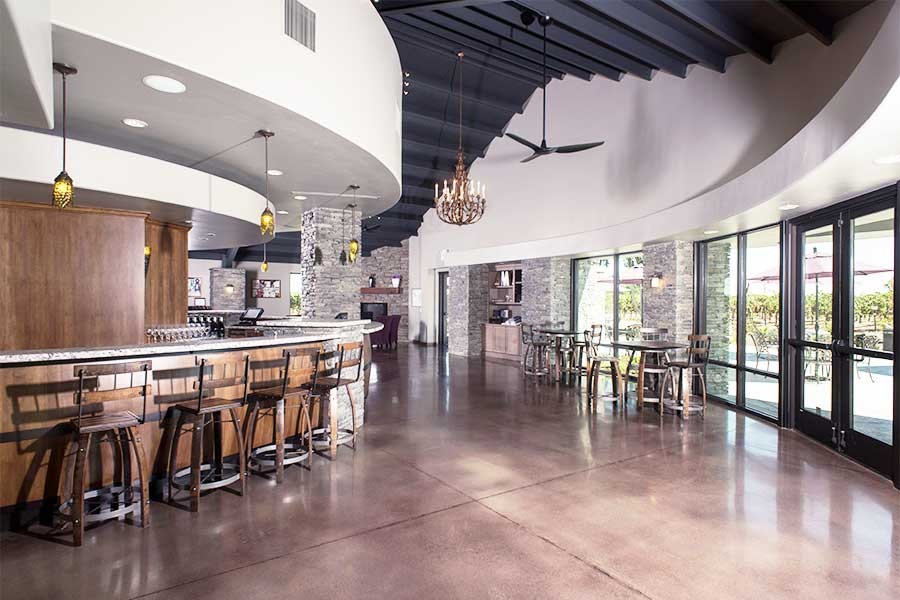 Photo of interior of Mettler Tasting Room, with bar seating, table seating and view out back windows